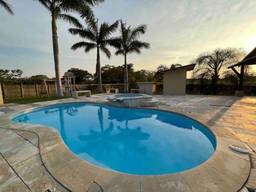 a large blue swimming pool with palm trees in the background at Tropical Hideaway with SharePool in Secure Condo, LIR in Guanacaste