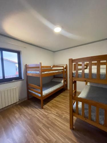 ポオ・デ・リャネスにあるEco-Hostel La Casa Verdeの二段ベッド2台と窓が備わる客室です。