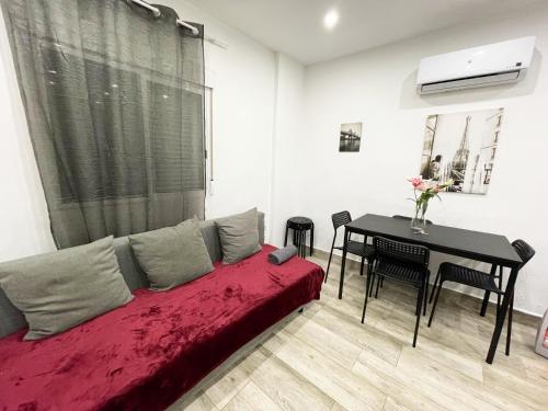 a living room with a red bed and a table at Apartments near metro in Madrid