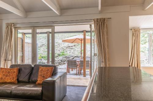 a living room with a couch and a table at Arrow Junction Cottage in Arrowtown
