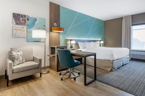 Pokój hotelowy z łóżkiem, biurkiem i krzesłem w obiekcie Comfort Suites Cottage Grove-Madison w mieście Cottage Grove