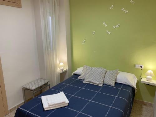 Un dormitorio con una cama azul con aviones en la pared en Beachfront and Cozy Apartment, en Cullera