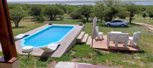 una piscina con una mesa y sillas y un coche en Cuesta pampa casa de campo en Toay