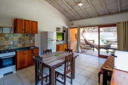 uma cozinha com uma mesa de madeira e uma sala de jantar em Pousada do Mica em Praia do Rosa