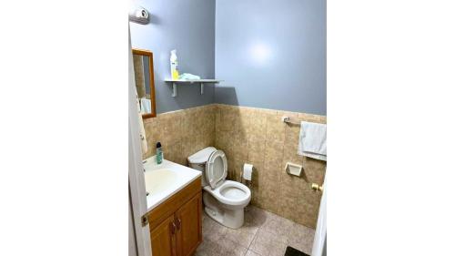 y baño con aseo y lavamanos. en Divine Guest House Room D. 6mins near EWR NEWARK Airport, 4mins to Penn Station / Prudential, en Newark