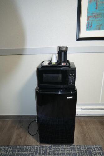 una macchinetta del caffè seduta sopra un forno a microonde di Best Motel a Seattle