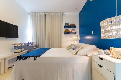 1 dormitorio con 1 cama grande y pared azul en Terraços Pirangi #17 - Conforto por Carpediem, en Parnamirim