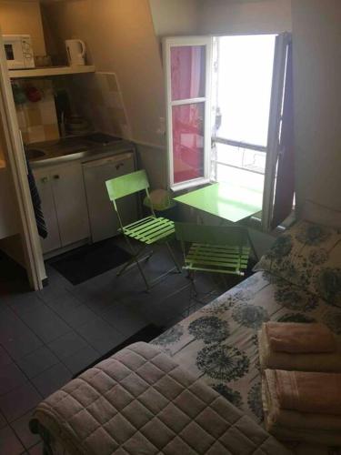 a kitchen with a bed and a table and a chair at Charmante chambre de bonne a Montorgueil Paris in Paris
