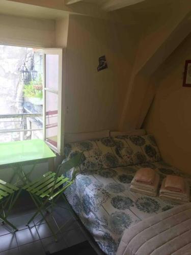 a small room with a bed and a window at Charmante chambre de bonne a Montorgueil Paris in Paris