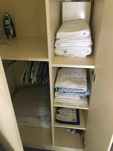 a white closet with towels and towels at Charmante chambre de bonne a Montorgueil Paris in Paris