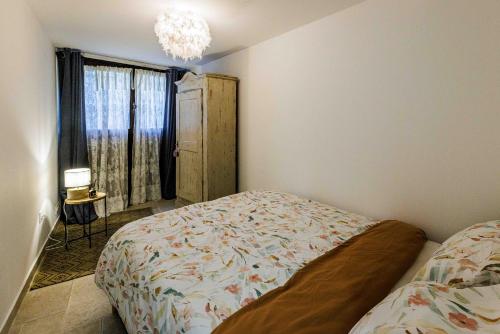 een slaapkamer met een bed en een raam bij L isle aux Rêves appartement plain-pied avec patio RDC in LʼIsle-sur-la-Sorgue