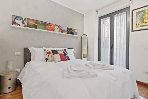 Un dormitorio blanco con una cama blanca y una ventana en [Milano-M1] Rock House, en Milán
