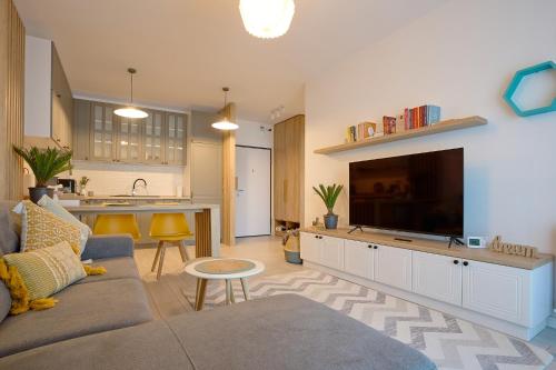 a living room with a couch and a large flat screen tv at Moon Plaza Deluxe Studios in Bucharest