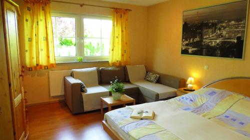 1 dormitorio con cama, sofá y ventana en Wellness Apartments Sophienhöhe AM TEICH, en Mechernich