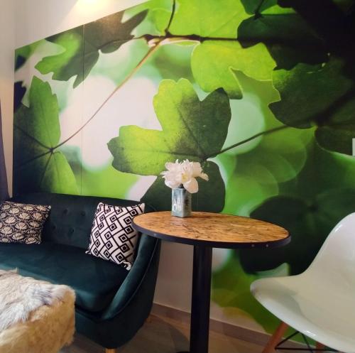 une table avec un vase de fleurs au-dessus d'un mur dans l'établissement Riviera Cocoon - Nice Center, à Nice