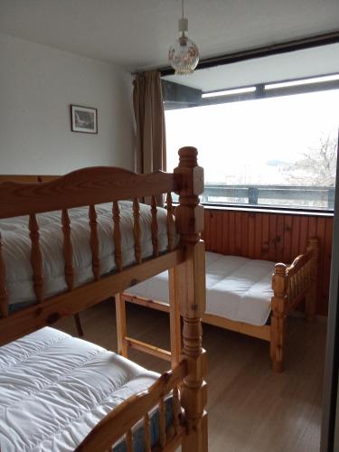 une chambre avec deux lits superposés et une fenêtre dans l'établissement Appartement plein cœur Super-Besse, à Besse-et-Saint-Anastaise