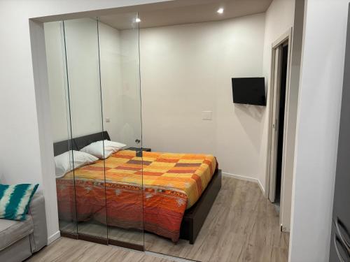 1 dormitorio con 1 cama con pared de cristal en ROYAL MILANO LINATE APARTMENTS, en Pantigliate