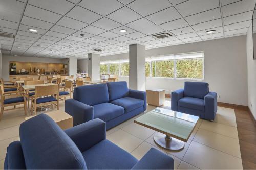 a waiting room with blue chairs and a table at City Express by Marriott Apizaco in Apizaco