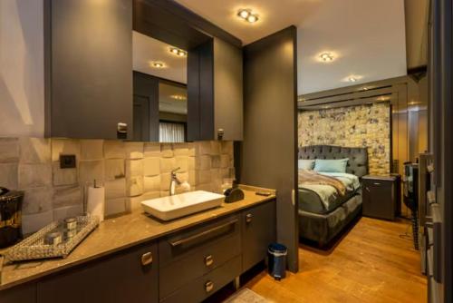 1 dormitorio con 1 cama y baño con lavabo. en Ortaköy Luxury Villa with Bosborus View en Estambul
