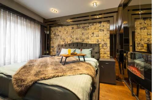 a bedroom with a large bed and a stone wall at Ortaköy Luxury Villa with Bosborus View in Istanbul