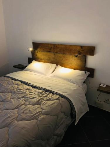 a bedroom with a large bed with a wooden headboard at La Casa del Capo - appartamento con 2 camere. in Venaria Reale