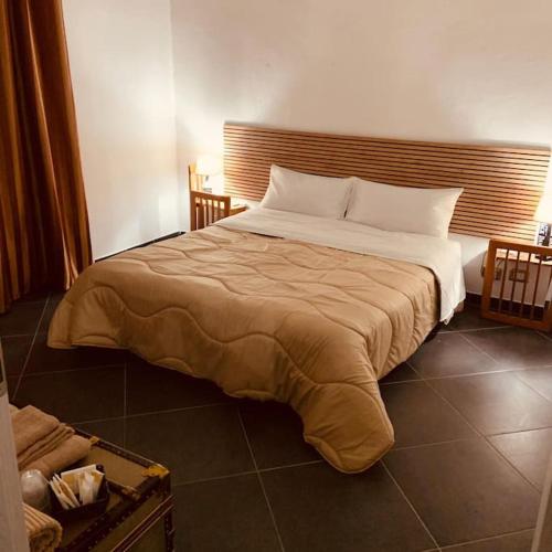a bedroom with a large bed with a wooden headboard at La Casa del Capo - appartamento con 2 camere. in Venaria Reale