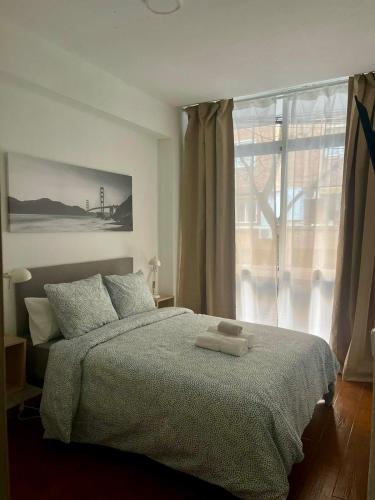 a bedroom with a bed with two towels on it at Rooms Cáceres in Madrid