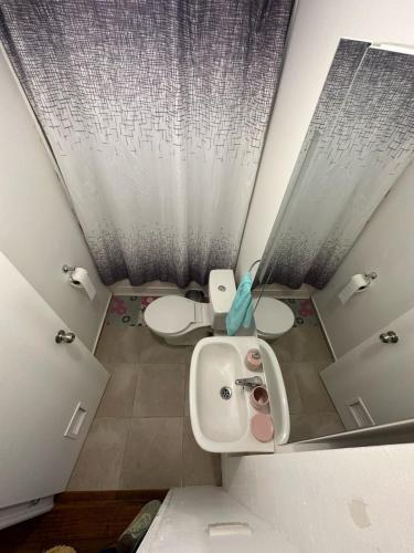 a bathroom with two toilets and a sink and a mirror at Apartamento punta Arenas in Punta Arenas