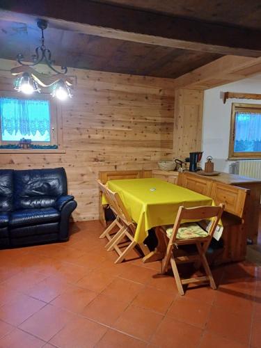 a dining room with a yellow table and chairs at Chalet Renzo in Livigno