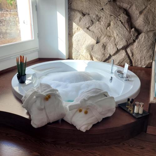 a bathroom with a tub with towels and a sink at Palazzo Ferrucci Luxury Suites in Cagliari
