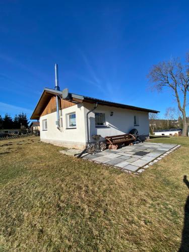 mały biały budynek z dachem na polu w obiekcie Ferienhaus in Schönheide im schönen Erzgebirge w mieście Schönheide