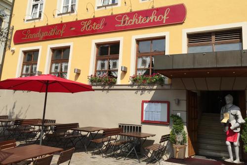 un restaurante con mesas y una estatua delante de él en Landgasthof-Hotel Lichterhof, en Uffenheim