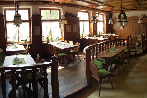 ein Restaurant mit Holztischen, Stühlen und Fenstern in der Unterkunft Landgasthof-Hotel Lichterhof in Uffenheim