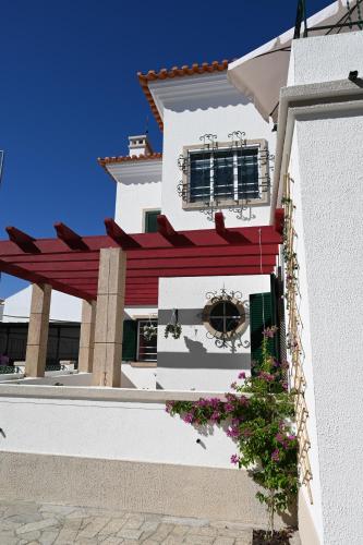 a white building with a window and flowers at Villa Sor in Ponte de Sor