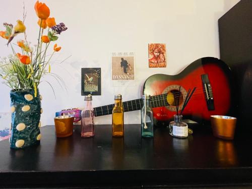 a wooden table with bottles and a guitar on it at Quiet and Colorfull Flat in the Center City of Brussels in Brussels