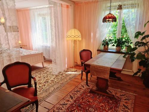 a dining room with a table and chairs and a room with a bed at Romantic apartment in Fjälkinge