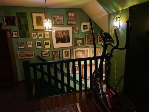 a hallway with a staircase with pictures on a green wall at Romantic apartment in Fjälkinge