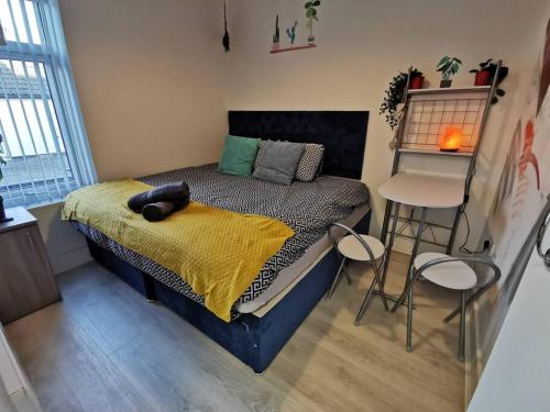een slaapkamer met een bed met een gele deken en stoelen bij Unique LFC Themed House in Liverpool