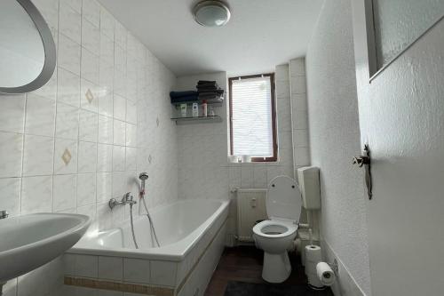 a bathroom with a tub and a toilet and a sink at Ferienwohnung Nappen platz in Bad Salzungen