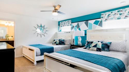 two beds in a room with blue and white at Windsor At Westside Superpower 8801 in Kissimmee