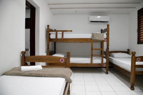 a room with three bunk beds in it at A Oca Hostel Bar in João Pessoa