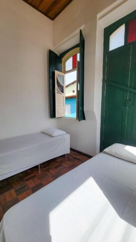 two beds sitting in a room with a window at Casa de Izaura in Lençóis