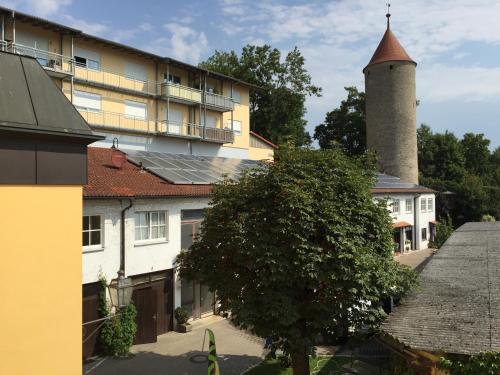 a building with a tower and a building with a tree at Landgasthof-Hotel Lichterhof in Uffenheim