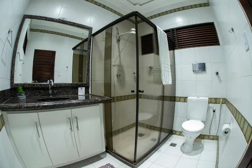 a bathroom with a shower and a toilet and a sink at A Oca Hostel in João Pessoa