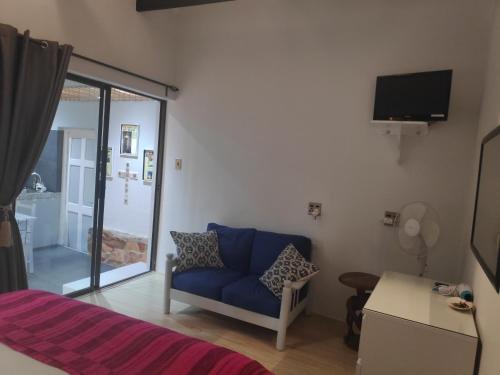 ein Schlafzimmer mit einem blauen Sofa und einer Glasschiebetür in der Unterkunft La Chapelle - The Apartment in Montagu