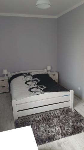 a bedroom with a white bed in a room at Apartamenty Motyl in Żywiec