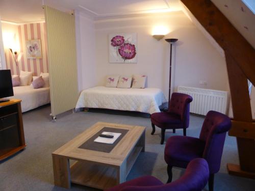 une chambre d'hôtel avec un lit, une table et des chaises dans l'établissement Logis - Hostellerie & Restaurant Saint Louis, à Bollezeele