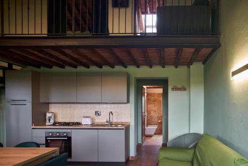 a kitchen and living room with a green wall at Podere Sant'Antonio in Asciano