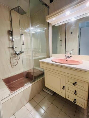 une salle de bain avec un lavabo et une douche en verre dans l'établissement Le Santorin - Deauville, à Deauville