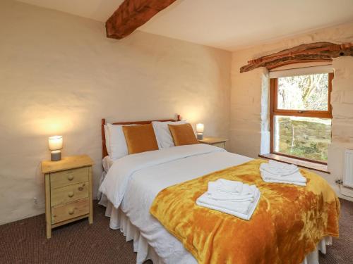 a bedroom with a large bed with towels on it at Y Felin in Llanybydder